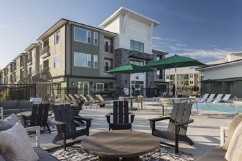 A poolside area with chairs and a table.